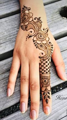 a woman's hand with henna tattoos on it