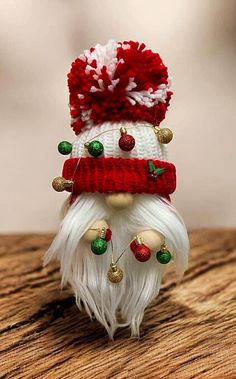 a small white and red gnome figurine on a wooden table