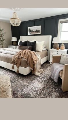 a bedroom with black walls, white furniture and an area rug on the floor that matches the bed