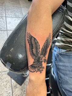 a person with a tattoo on their arm and an eagle in the middle of it