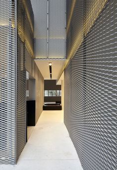 an empty hallway is shown with metal slats on the walls and flooring in front of it