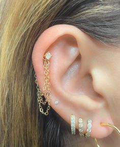 a close up of a person's ear with three different types of jewelry on it