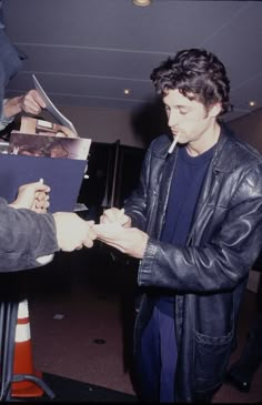 a young man is signing autographs for someone to sign on his birthday card at the airport