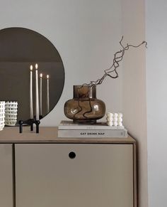 a dresser with candles and a mirror on top