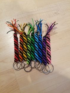 several multicolored keychains sitting on top of a wooden table