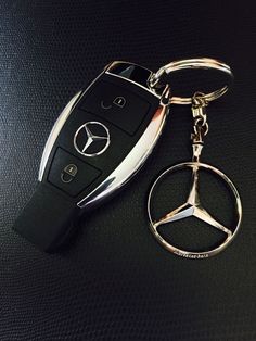 a car keychain with a mercedes logo on it and a remote control attached to the key chain