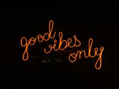 a neon sign that says good vibes only in the dark with orange writing on it