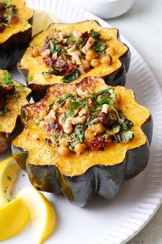 baked stuffed acorns on a plate with lemon wedges and garnish