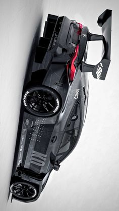 a black and white photo of a race car on the wall with its hood up