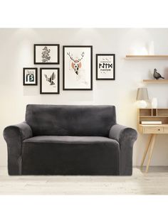 a living room with pictures on the wall and a gray couch in front of it