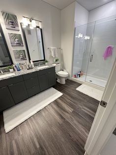 a bathroom with wood floors and gray cabinets