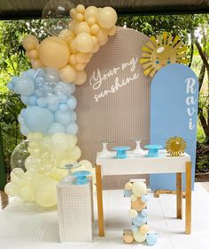 a table with balloons and decorations for a baby's first birthday party on it