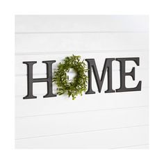 the word home is made out of metal letters with a wreath hanging from it's center