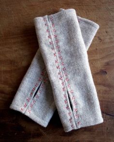 two white towels sitting on top of a wooden table next to each other with red flowers