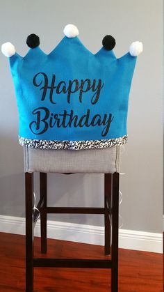 a blue birthday crown sitting on top of a wooden chair