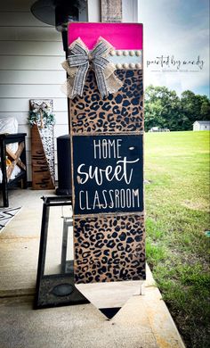 a sign that says home sweet classroom on the side of a house in front of some grass