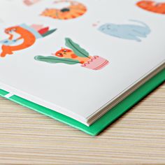 a close up of a book with animals on it's cover and green binding