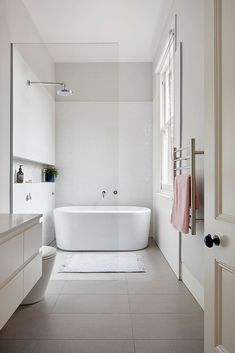 a white bath tub sitting next to a toilet in a bathroom