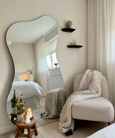 a bedroom with a large mirror on the wall next to a chair and small table