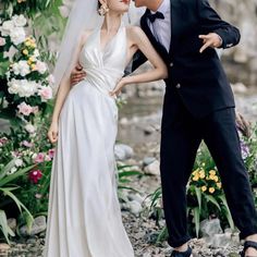 a bride and groom kissing in front of flowers