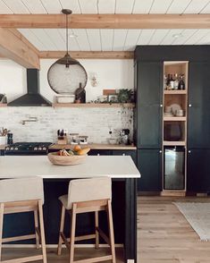 a kitchen with black cabinets and white counter tops