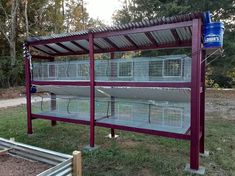 two large cages sitting on top of each other in front of a fenced off area