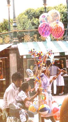 some people are sitting at a table with balloons