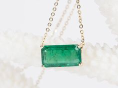 This elegant, timeless necklace features a stunning 3.76ct rich green Zambian emerald that is the focal point of the design. The emerald is set into a classic prong design that can be worn vertically or horizontally on the chain to suit any occasion. With this necklace, you can easily transition from a day in the office to a night on the town. ♥ The pendant measures 7mm in width, 13mm in length, and is 5.5mm thick. ♥ The necklace chain shown is included and measures 17.5" with a slider bead that Formal Single Strand Emerald Necklace, Classic Green Necklace With Rectangular Pendant, Elegant Green Emerald Necklace With Rectangular Pendant, Timeless Emerald Necklace Gift, Elegant Emerald Cut Emerald Necklace For Formal Occasions, Timeless Emerald Pendant Necklace Gift, Formal Fine Jewelry Emerald Necklace With Baguette Cut, Green Emerald Baguette Cut Necklace, Formal Fine Jewelry Baguette Cut Emerald Necklace