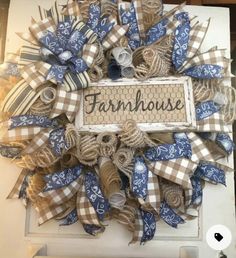 a blue and white wreath with the word farmhouse on it