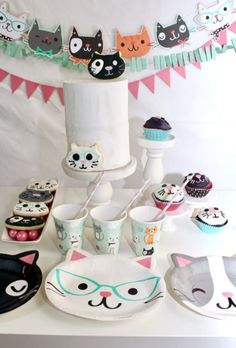 a table topped with lots of cupcakes and cake