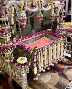 an elaborately decorated bed with flowers and beads on the headboard is shown in front of a mirror