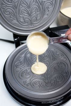 a person pouring sauce on top of a pancake in front of other pans