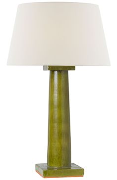 a green table lamp with a white shade on the top and an orange base underneath