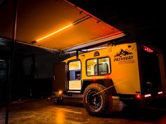 an off - road vehicle parked in the dark with its door open and lights on