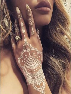 a woman with henna tattoos on her hands and hand is holding the other hand