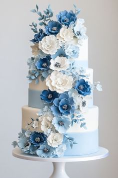 a three tiered cake with blue and white flowers