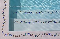 three pieces of glass sitting in the middle of a swimming pool with water reflecting them