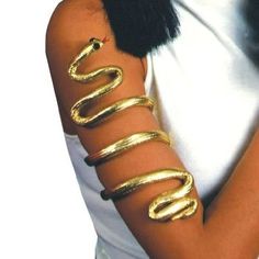 a woman is wearing gold bracelets and a white shirt with black fur on it