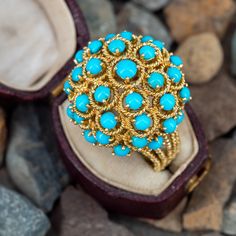 This gorgeous domed style ring features rope details and is prong set with thirty-six (36) round turquoise cabochons. The ring measures 22.7mm at the top, rises 16.6mm above the finger, tapering to 5.9mm wide and 1.8mm thick at the base of the shank. The ring is a size 6. We are not offering resizing due to the design of the ring. Luxury Turquoise 14k Gold Ring, Gold Turquoise Cabochon Ring In 14k Gold, Luxury Turquoise Cabochon Ring In Yellow Gold, Luxury Cabochon Turquoise Ring, Luxury Gold Cabochon Turquoise Ring, Prong Setting, Turquoise Ring, Jewelry Rings, Yellow Gold