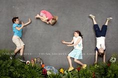 three children are jumping in the air with their hands up and one child is upside down