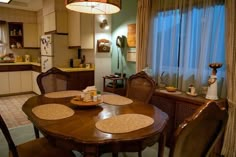 a dining room table and chairs in front of a window