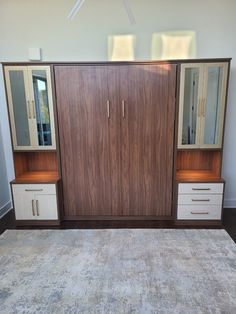 a room with a rug, cabinet and mirror on the wall next to each other