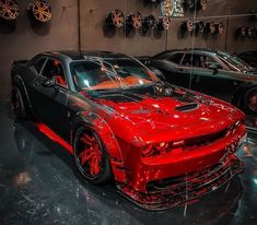 some very nice looking cars on display in a showroom with red and black paint