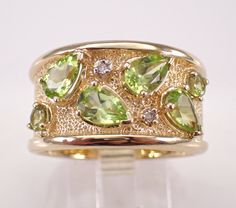 14K Yellow Gold Diamond and Peridot Wedding Anniversary Ring.  This ring is set with two Round Peridot, four Pear shaped Peridot and two Round Brilliant Diamonds.  These Peridot amount to a total weight of 2 1/4 carats.  The diamonds in this ring are H color, I1 clarity and weigh a total of .02 carat. This ring is 14KT Yellow Gold, weighs 8.8 grams, measures 12.5 mm in width and is a finger size 8 3/4, which is resizable (please inquire about sizing with the finger size you need). The ring will be accompanied by an appraisal by a GIA Certified Diamond Grader with the retail replacement value of $3,289.00. I will ship this ring promptly in a gift box. Luxury Peridot Rings For Women, Luxury Peridot Diamond Ring With Accent Stones, Formal Multi-stone Peridot Jewelry, Peridot Gemstone Wedding Jewelry, Wedding Jewelry With Peridot Gemstone Accents, Anniversary Peridot Jewelry With Diamond Accents, May Birthstone Jewelry With Single Cut Diamonds For Wedding, Wedding Jewelry With Single Cut May Birthstone Diamonds, Wedding Rings With Peridot Gemstone Accents