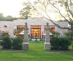 an outside view of a building with lawn and trees in the foreground at sunset