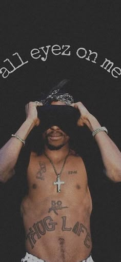 a shirtless man holding his hat over his eyes with the words all eyez on me above him