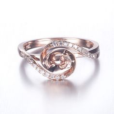 a rose shaped diamond ring on a white surface