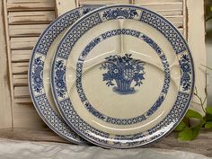 two blue and white plates sitting next to each other