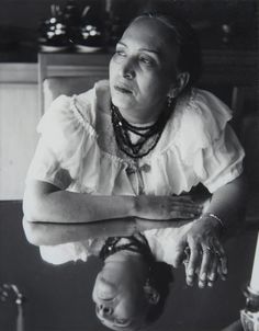 an old photo of a woman with her hands on her chest and looking up at the sky