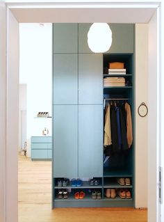 an open closet with clothes and shoes in it